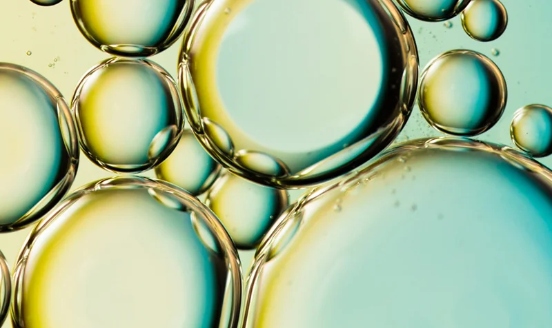 Macro di bolle colorate verde e dorato – principi attivi in formulazione dermocosmetica